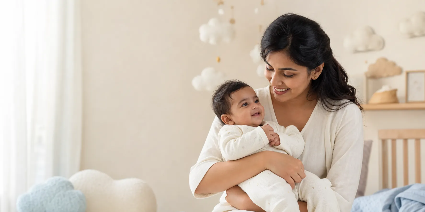 Indian mother holding her smiling baby in a calm nursery
